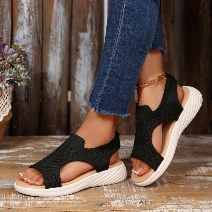 Front side view of black breathable slingback sandals worn with cropped jeans