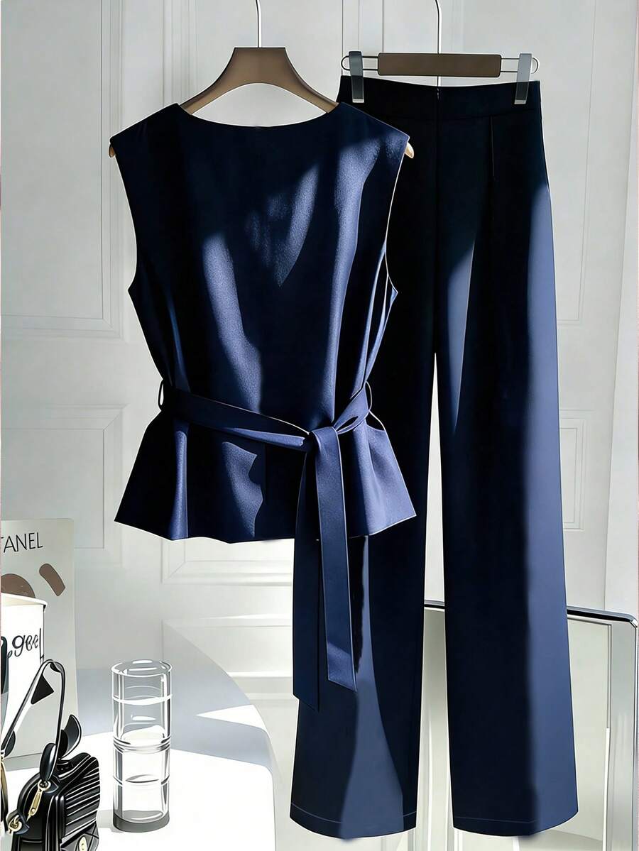 Perfect for the modern professional, this retro-inspired 2-piece set combines timeless style with practical comfort. The sleeveless camisole features a notched neckline and cinched waist design that flatters your silhouette, while the coordinating long pants complete the sophisticated look. Equipped with functional belt loops, pockets, and a zipper for everyday ease. Made from durable 100% polyester in versatile navy blue.
