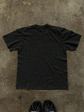 Back flat lay of plain black short-sleeve crew-neck T-shirt on concrete
