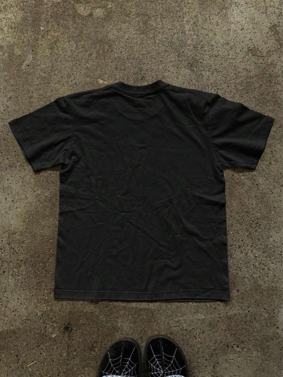 Back flat lay of plain black short-sleeve crew-neck T-shirt on concrete