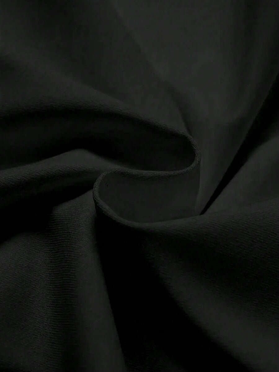 Close-up of black matte knit T-shirt fabric with gathered folds and fine texture