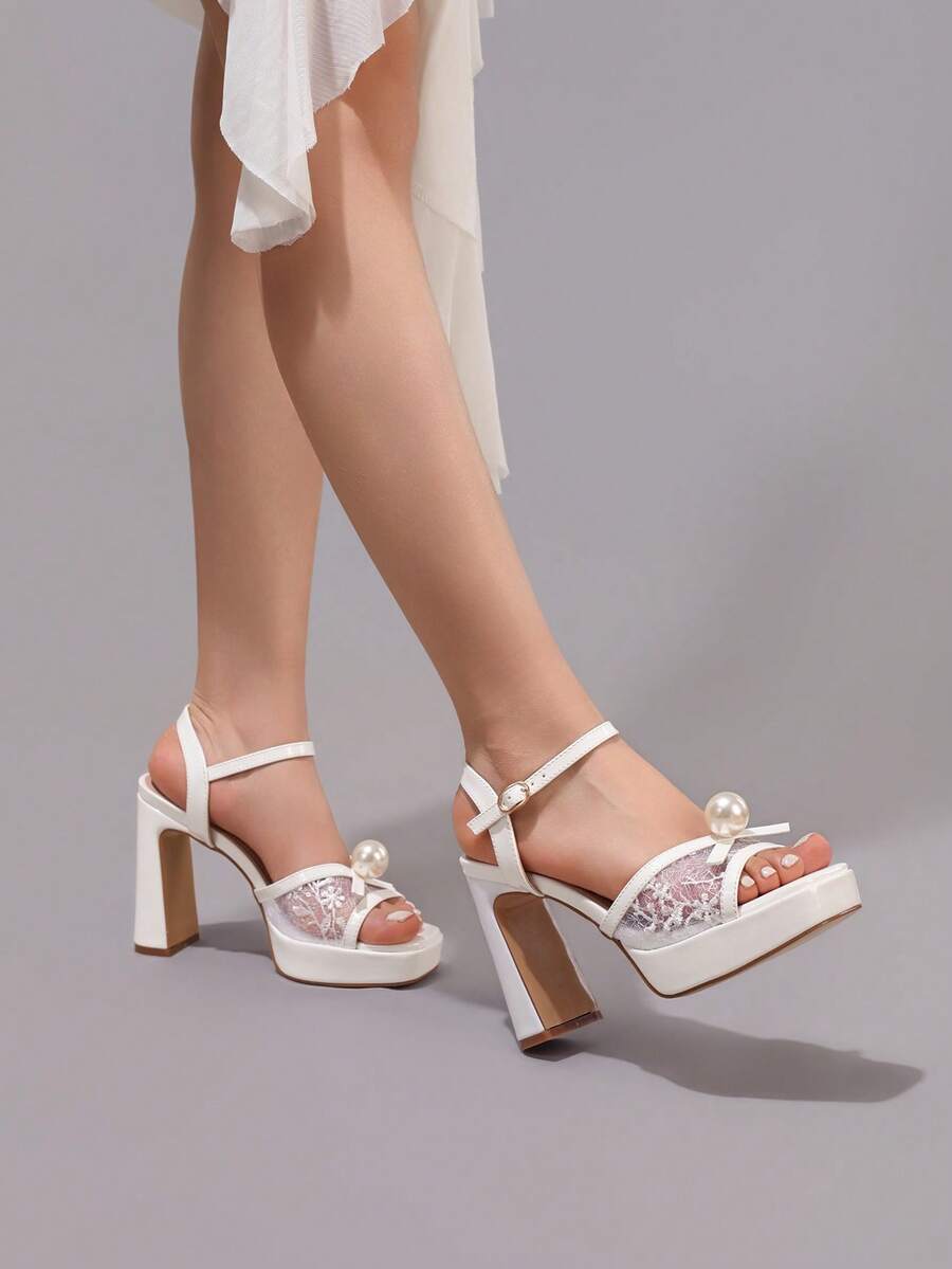 White pearl bow platform sandals worn by model with ankle buckle straps