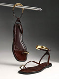 Studio view of brown thong sandals with gold-tone toe and ankle hardware