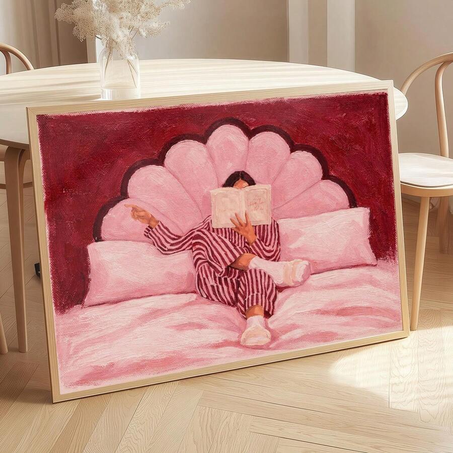 Angled dining room mockup of pink reader canvas art in a light wood frame