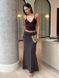 Three quarter front view of brown crop top and high waist ruched maxi skirt set