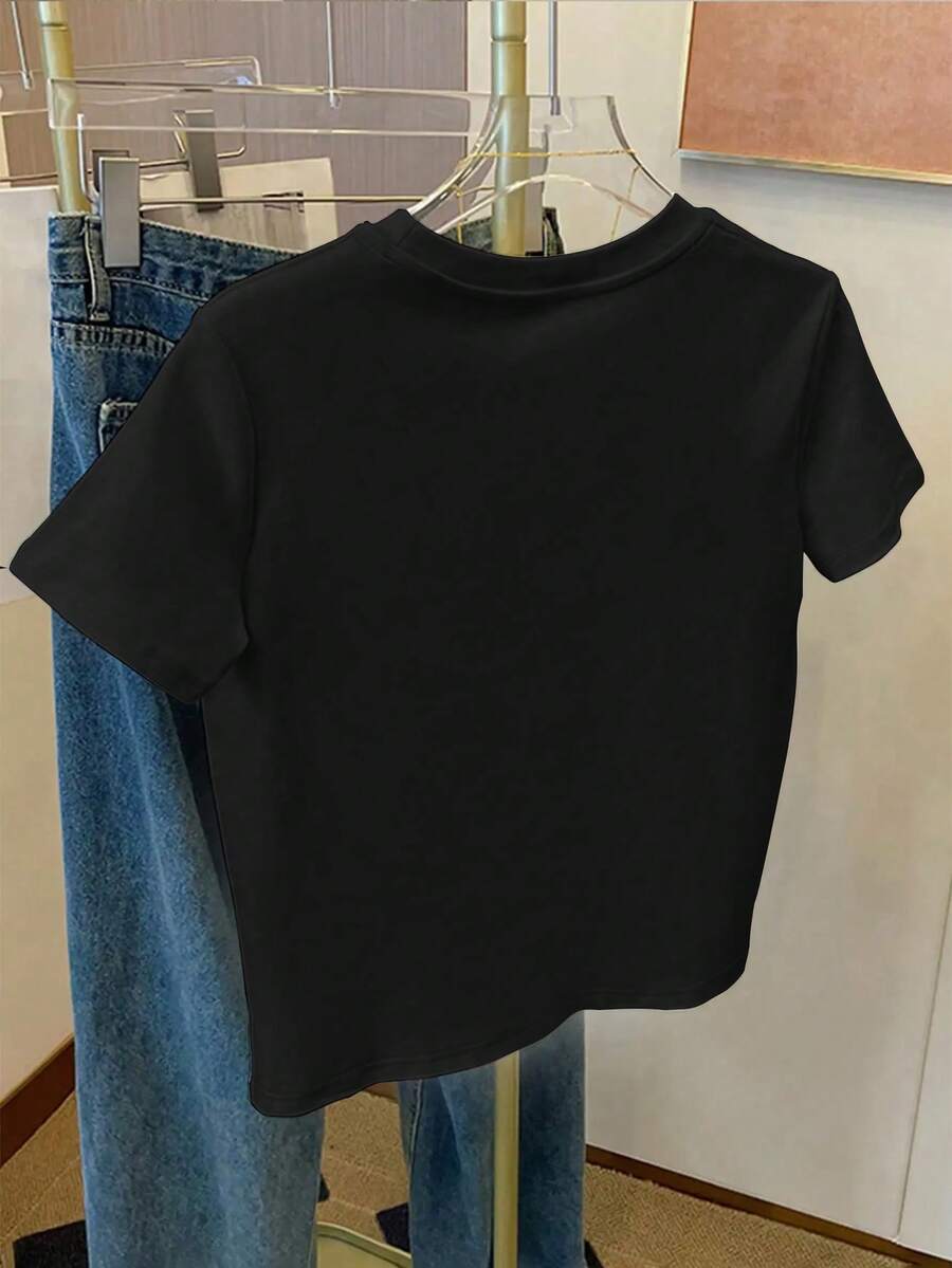 Front view of plus size black short sleeve graphic tee with white slogan and raised daisy appliques