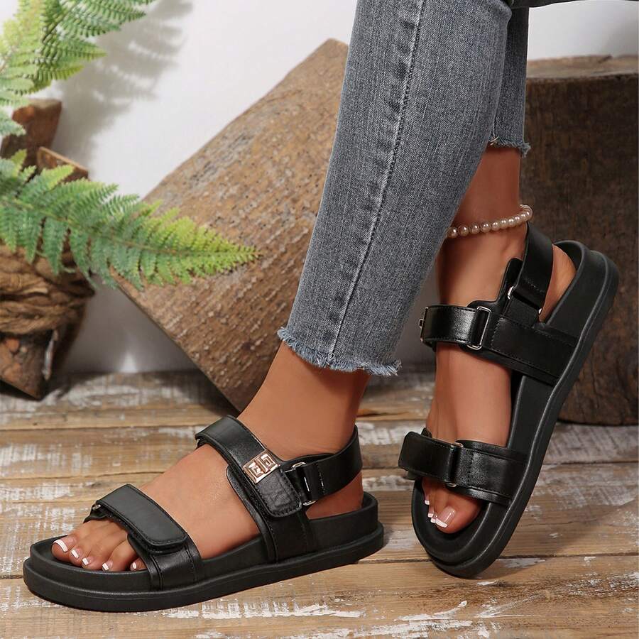Side profile of black PU leather platform sandals worn with jeans for casual outings
