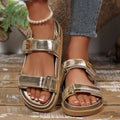 Front three-quarter view of champagne open toe sandals with reflective PU leather finish