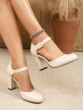 Back angle of cream block heel shoes showing high heel and black sole edge