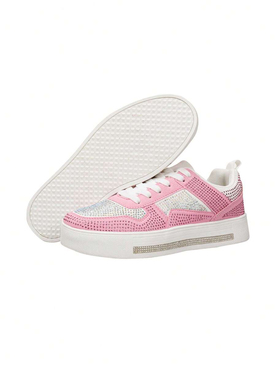Side and outsole view of pink rhinestone sports shoes showing textured white tread