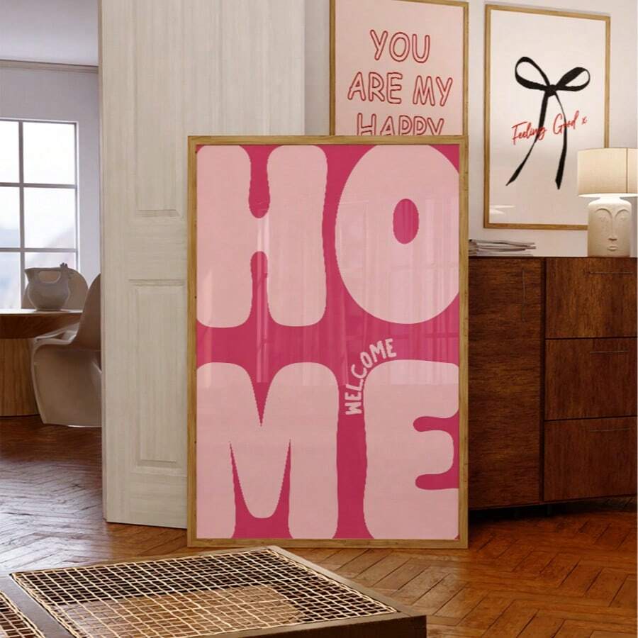 Pink Welcome Home typography print in a gold-tone frame styled in a living room
