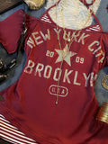 Close-up of burgundy New York graphic top with striped insert and distressed lettering