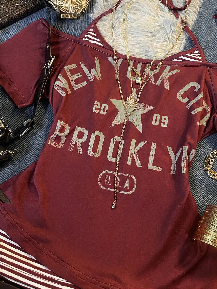 Close-up of burgundy New York graphic top with striped insert and distressed lettering