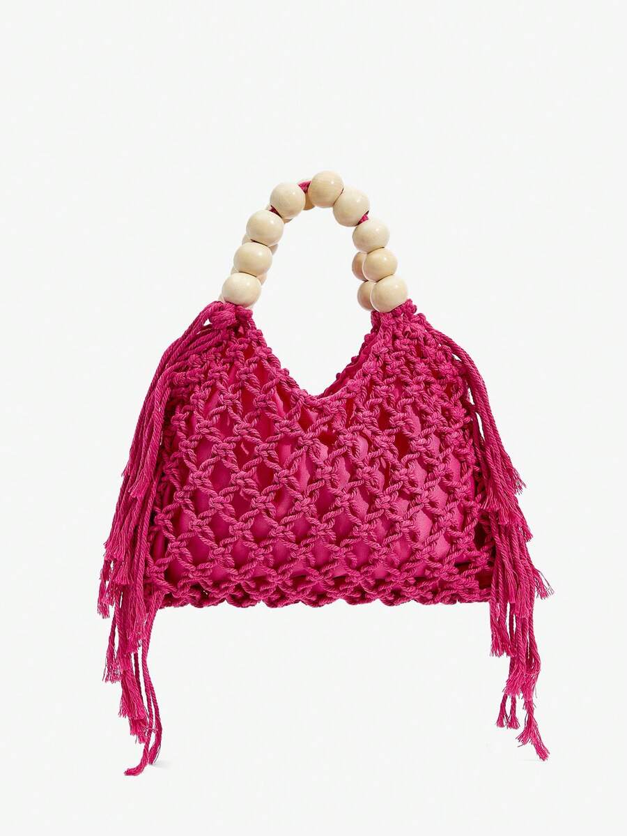 Hot pink crochet hollow beach bag with cream bead handle and side tassels