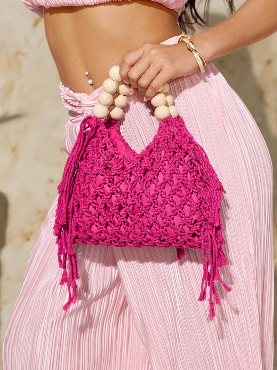 Hot pink crochet beach bag with cream bead handle and long side fringe