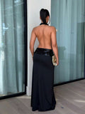 Back full body view of black backless halter maxi dress with floor length skirt