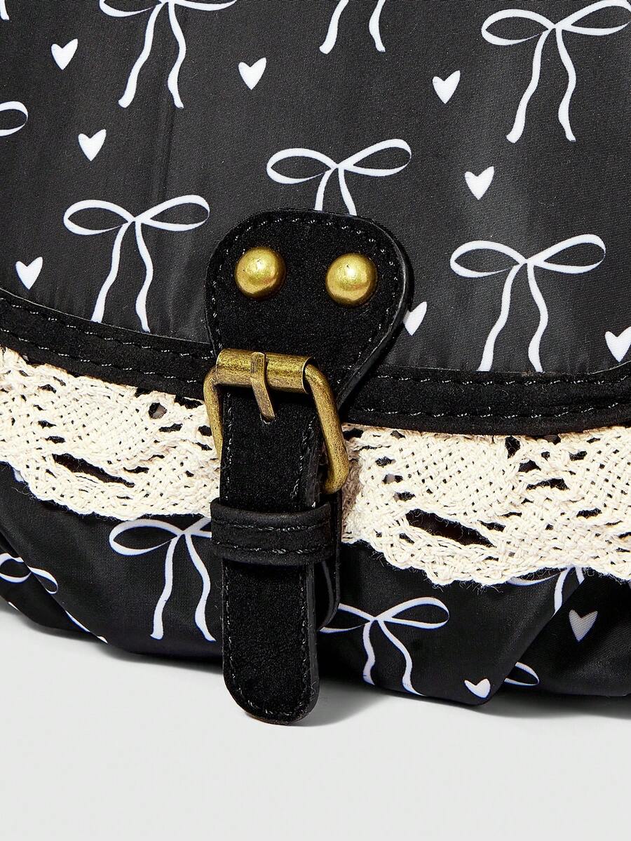 Black kawaii shoulder bag showing bow print rounded body and hardware