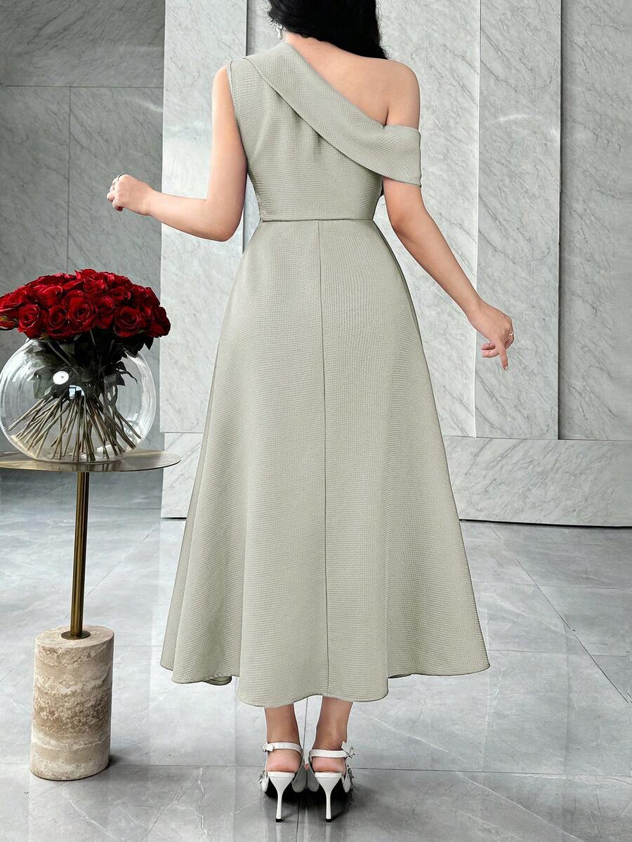 Back view of sage green asymmetric A-line midi dress with diagonal shoulder band in marble interior