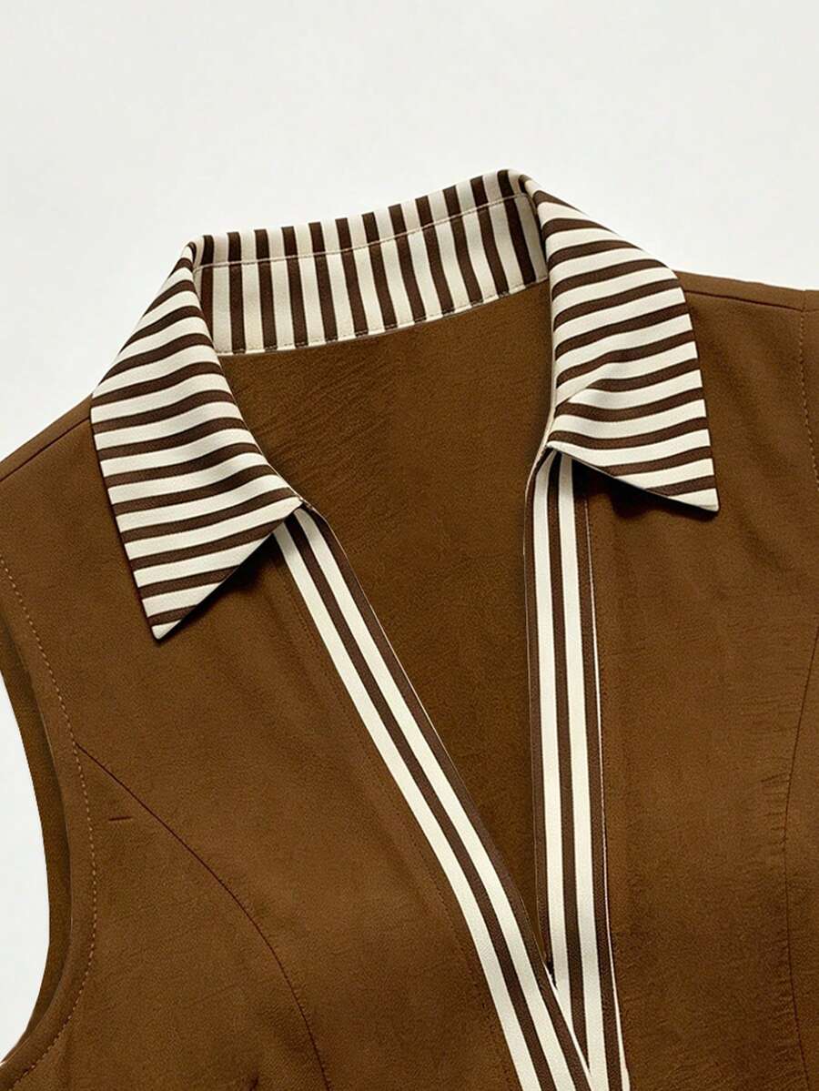 Close detail of brown shirt dress with striped collar and sleeveless armhole