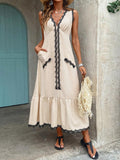 Full front view of cream lace trim maxi dress styled with woven fringe bag