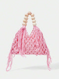 Pink crochet beach bag front view with hollow weave matching tassels and cream bead handle