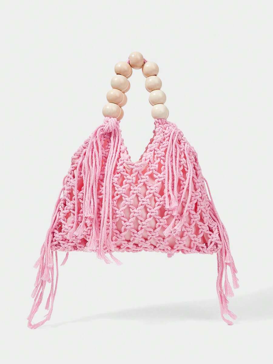 Pink crochet beach bag front view with hollow weave matching tassels and cream bead handle