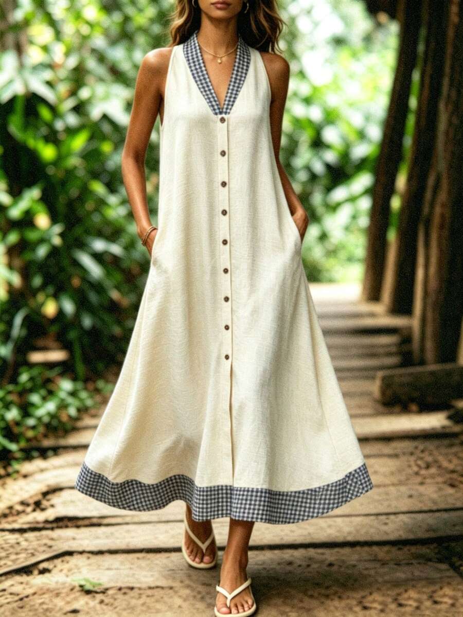 Outdoor view of cream button front halter dress with pockets and swing hem