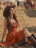 Rust orange boho sundress seated front view with ruffle hem and western styling