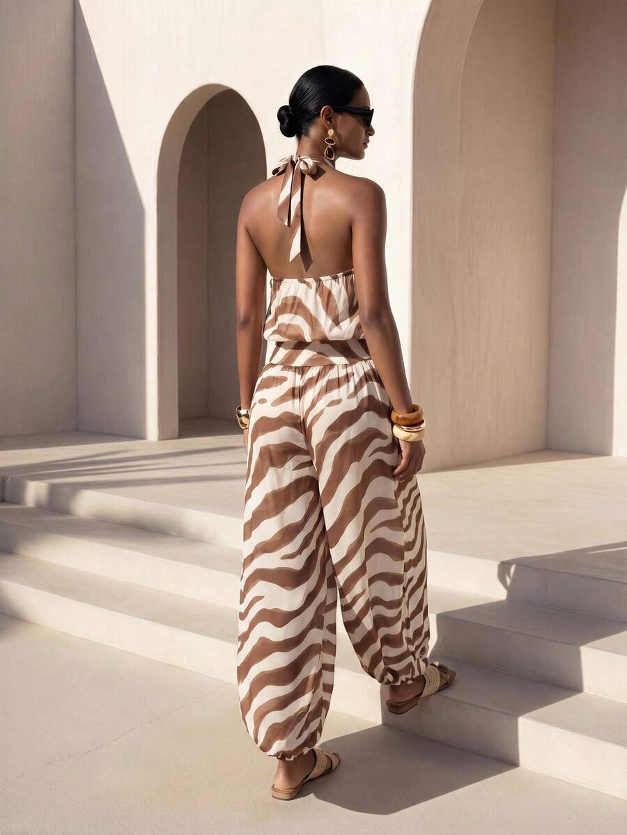 Front courtyard view of brown striped halter jumpsuit with twisted neckline and harem legs