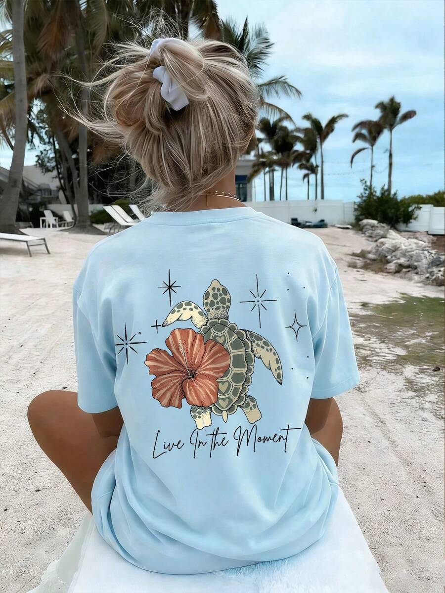 Back model view of baby blue turtle floral graphic tee with Live In the Moment print