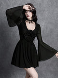 Front detail of black gothic dress showing deep V neckline and dimensional rose appliqué