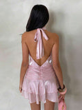 Back view of light pink halter mini dress with tied neck and V-shaped open back