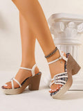 Hand-held beige open toe sandal showing tribal footbed and chunky heel