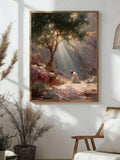A framed art print depicting a serene outdoor landscape with sunbeams, a tree, rocks, and a kneeling figure, displayed on a white wall in a styled room with a chair and potted plants.
