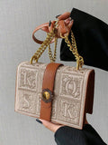 Black mini box crossbody bag with chain strap and structured rectangular shape