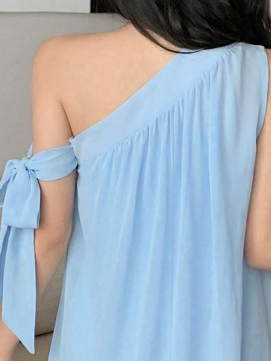Close detail view of light blue one-shoulder A-line mini dress showing visible color, print, and silhouette