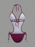 Back studio view of burgundy halter cutout one-piece swimsuit with open back and tie details for beach party styling