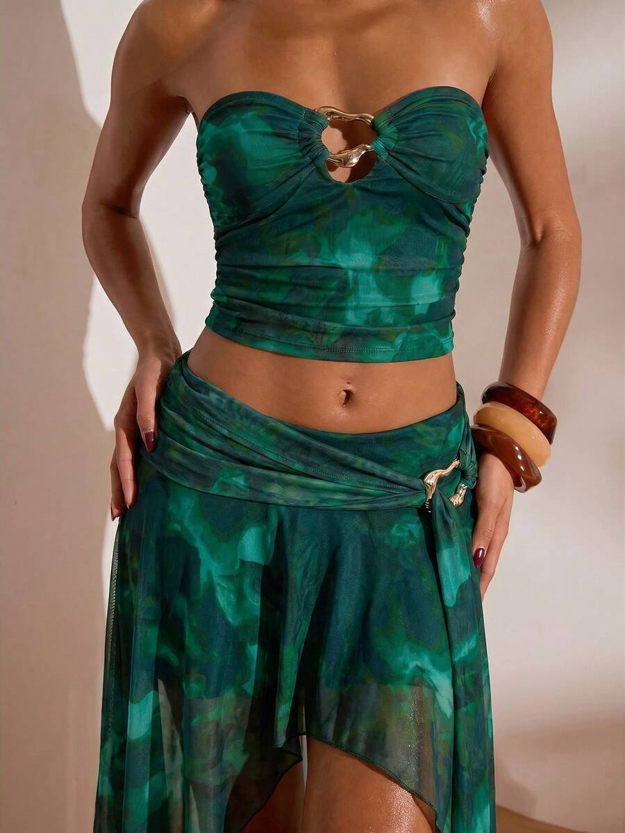 Front studio view of teal abstract print mesh bandeau crop top and flowing high-slit maxi skirt two-piece set for beach vacation styling