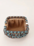 Open blue printed clutch showing tan fabric lining and gold tone metal side hinges