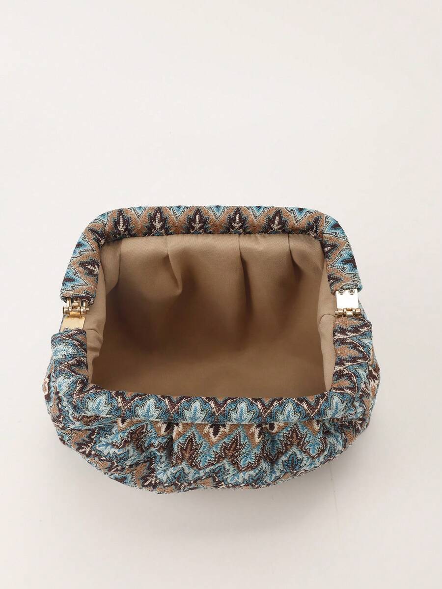 Open blue printed clutch showing tan fabric lining and gold tone metal side hinges