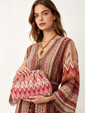 Model holding red pink cream zigzag printed bohemian clutch with pleated pouch shape