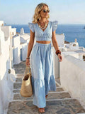 Front view of blue white striped crop top and wide leg pants set on coastal stairs