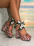 Black variant detail view of polka dot platform sandal with bow ankle tie
