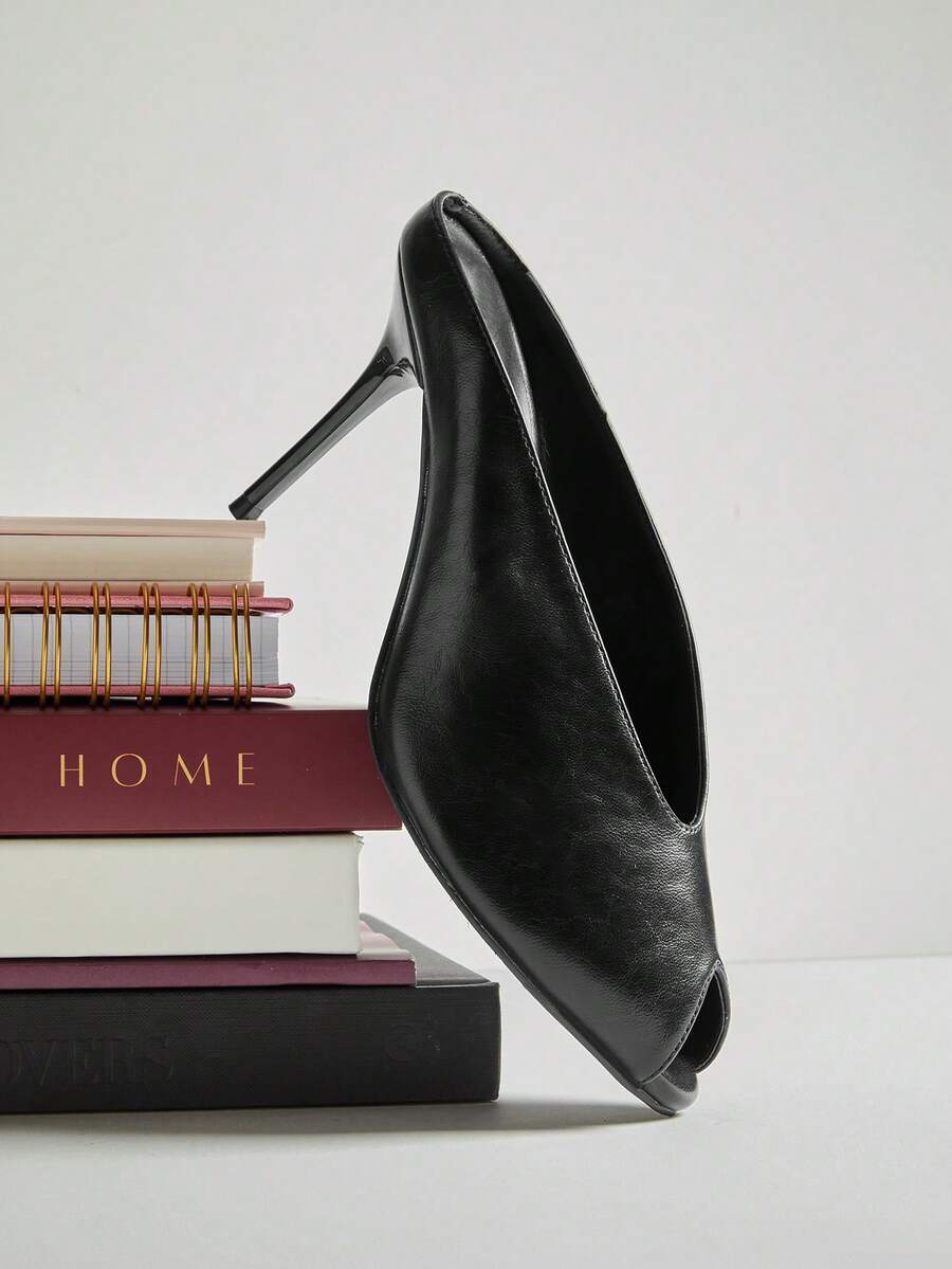 Black side-profile worn view of peep-toe stiletto mule sandals with a backless slip-on upper and slim high heel