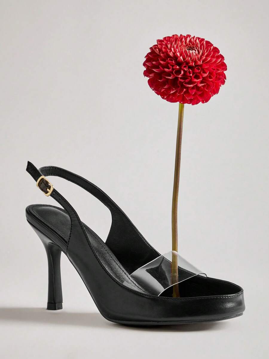 Black clear PVC slingback stiletto beside a red dahlia