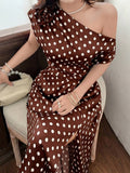 Seated close-up of coffee brown polka dot dress and floral shoulder