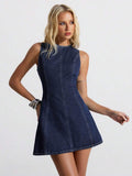 Three-quarter front portrait of dark indigo fitted denim mini dress with high round neckline