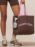 Pink canvas sport tote bag with brown musera sport logo and shoulder straps