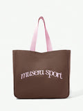 Close view of pink oversized shopper bag showing front logo and canvas texture