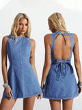 Front and back view of medium-wash denim mini dress showing open back and waist bow